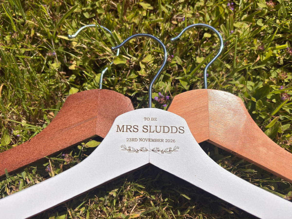 White, light wood and dark wood wedding hangers displayed together.
