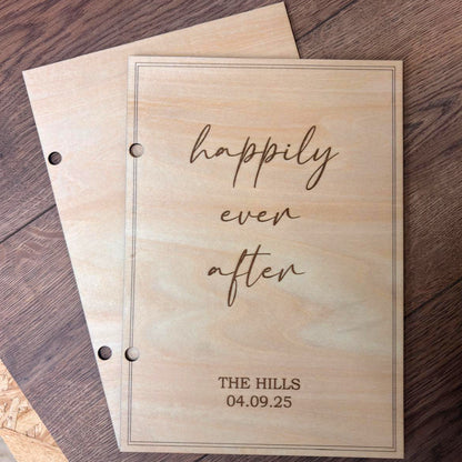 Natural wooden front and back covers of a personalised wedding card keepsake book with engraved border and wedding date.